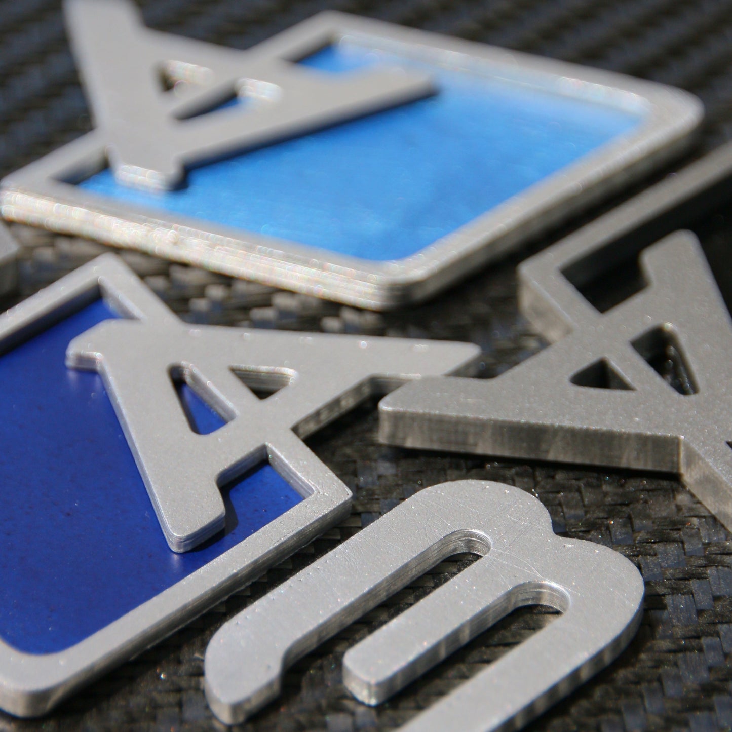 Chrome Audi trunk badge upgrade by CHIMERA STUDIO, showcasing a sleek, metallic badge for enhanced vehicle style.