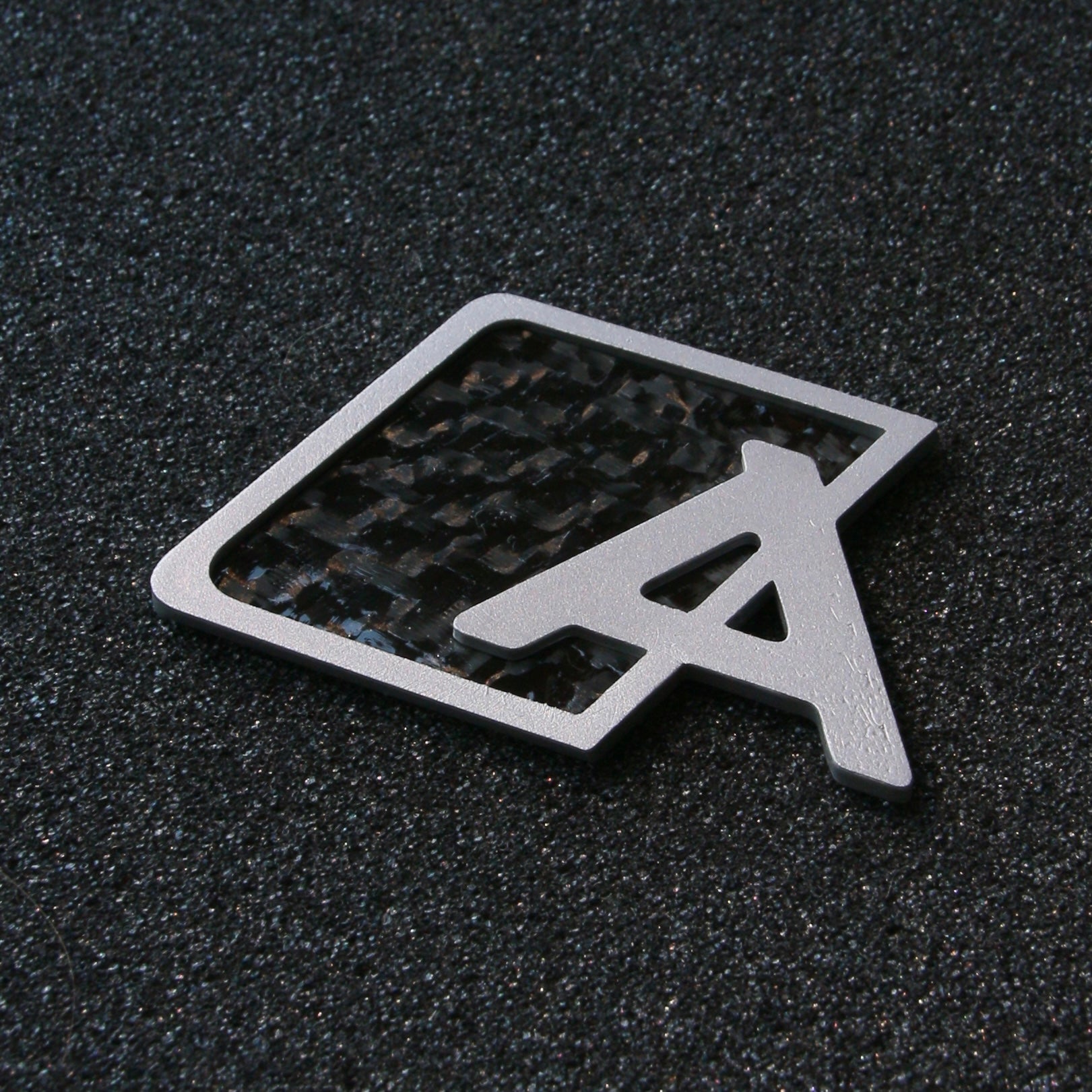 Carbon fiber Audi trunk badge upgrade by CHIMERA STUDIO, featuring sleek, modern design for a stylish vehicle enhancement.