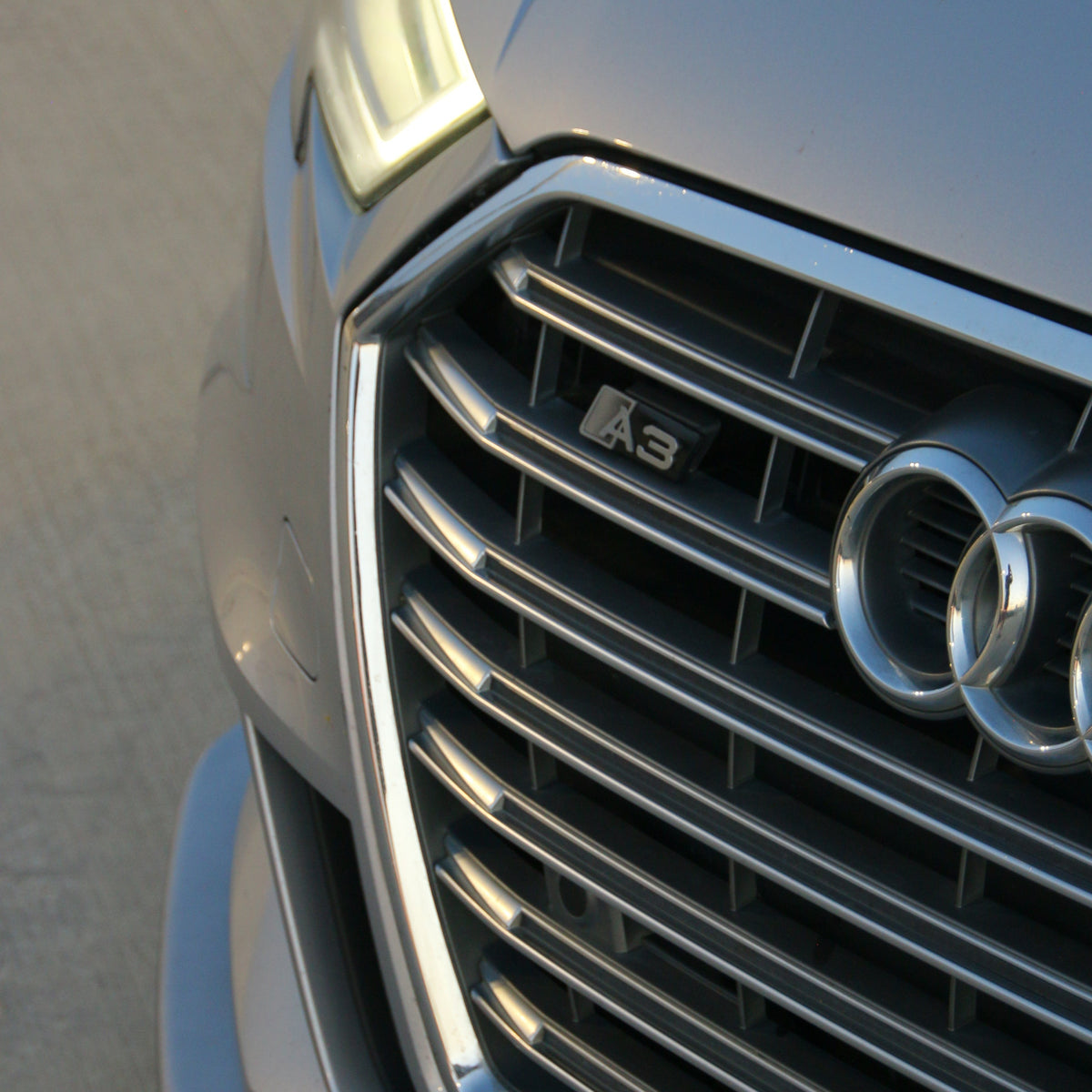 Chimera Studio badge mounted on the grille of a silver Audi A3