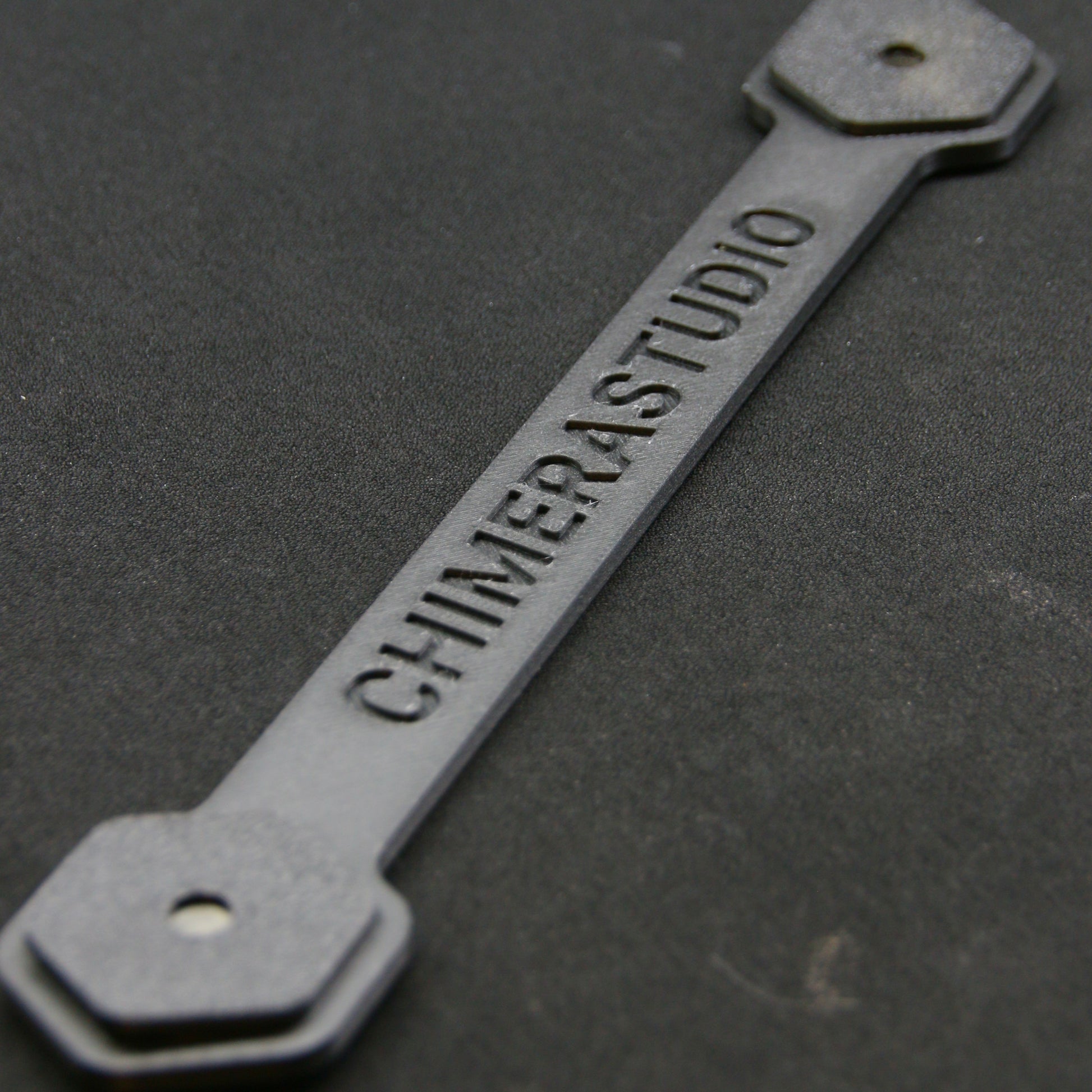 Magnetic V2 License Plate Bracket by CHIMERA STUDIO, showcasing a sturdy black metal mount for easy attachment to vehicle.